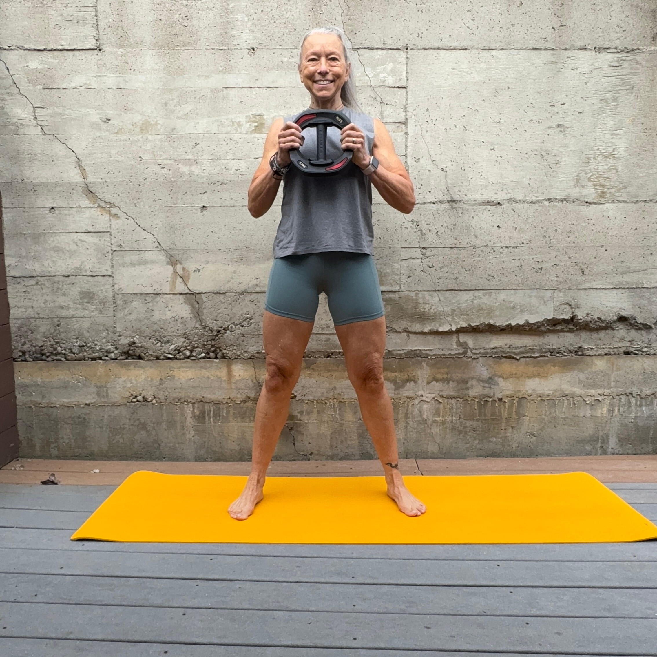 Woman exercising with weight plate