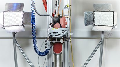 The MIPS crash dummy head with helmet upside down in lab testing machinery 