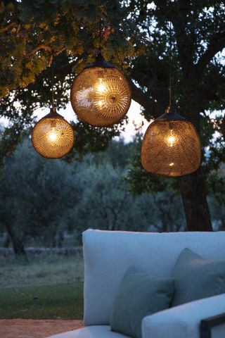 Tribu Monsieur Tricot garden lamps in a wild expansive garden space, with a white sofa