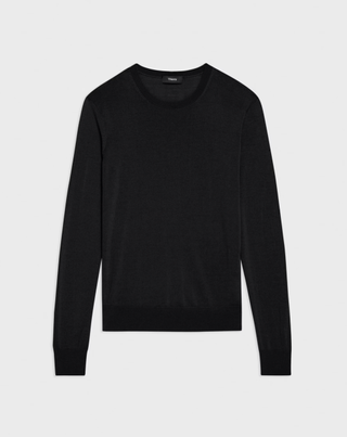 a black crewneck sweater from Theory in front of a plain backdrop