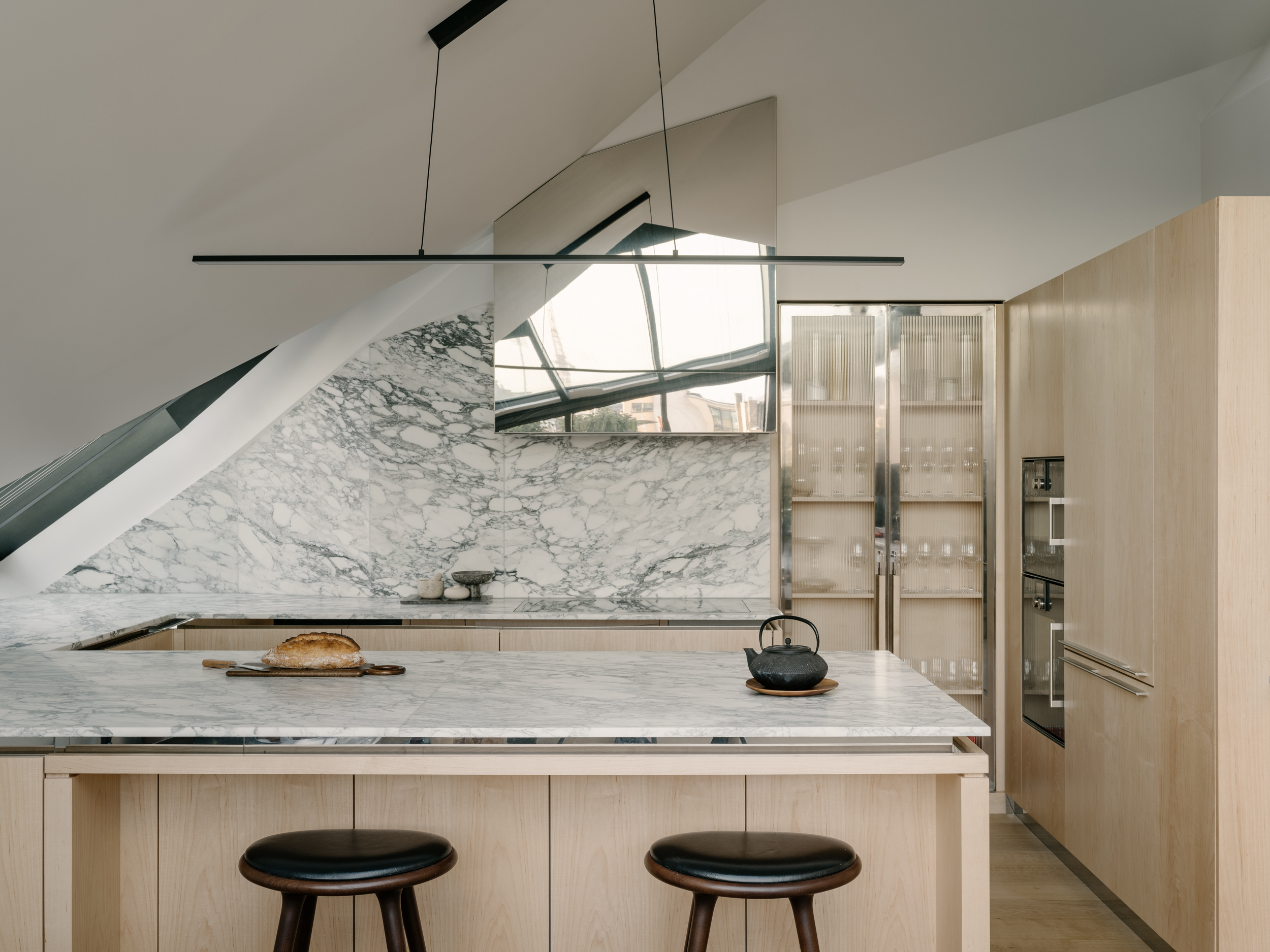 The kitchen features extensive use of Arabescato marble
