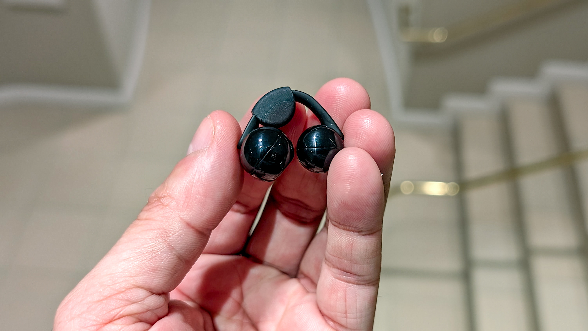 The Sony LinkBuds Clip in a Tom's Guide reviewer's hands and ears.