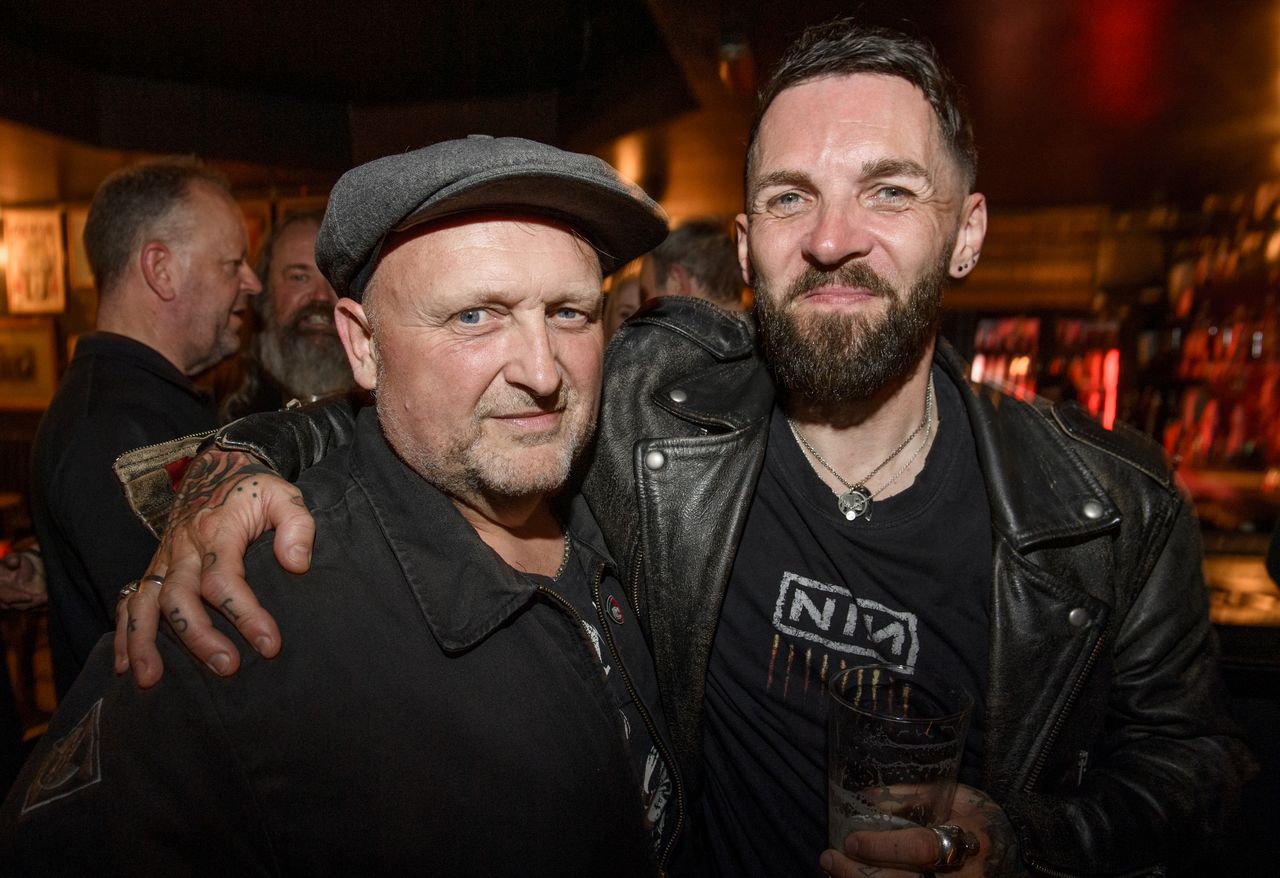 People drinking, smiling and throwing horns at the Metal Hammer 400 party