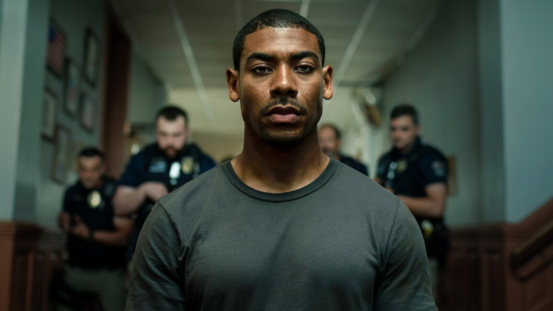 Aaron Pierre as Terry Richmond standing in front of a group of policemen during the Netflix movie, Rebel Ridge.