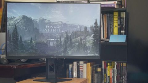En HP Omen 27c framför en bokhylla med Halo Infinite som spelas på skärmen.