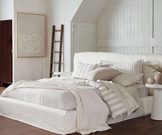 Somerset Stripe Throw Pillows on a bed against a white wall.