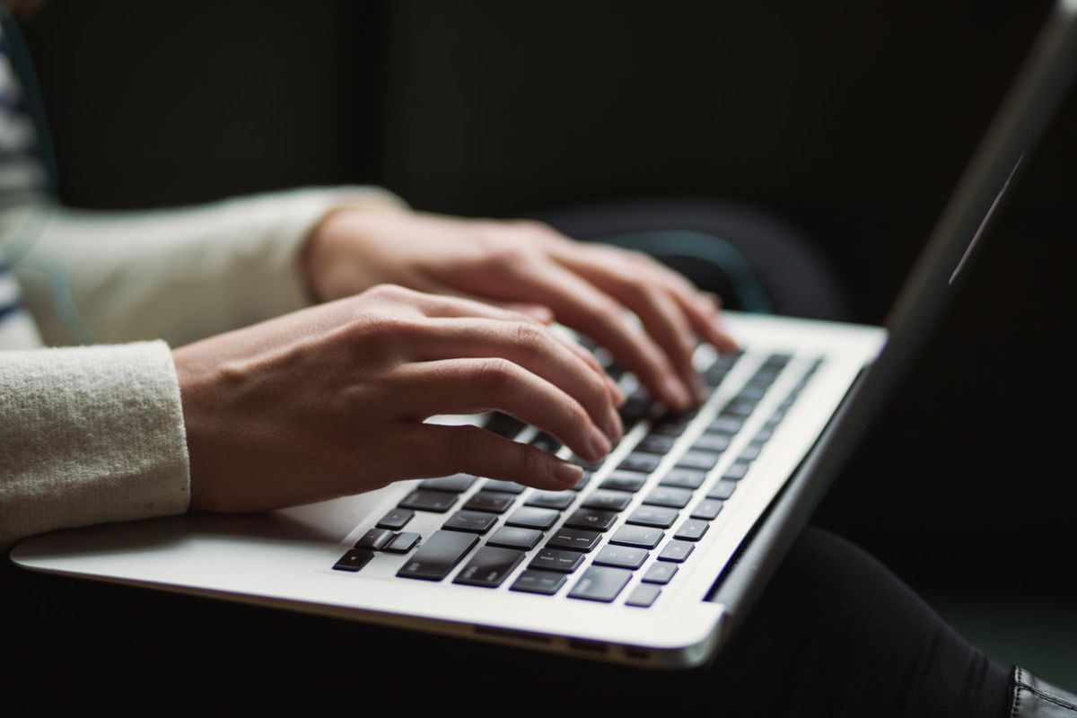 Hands typing on laptop computer keyboard