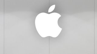 Apple logo pictured in white on a grey background at an Apple store.