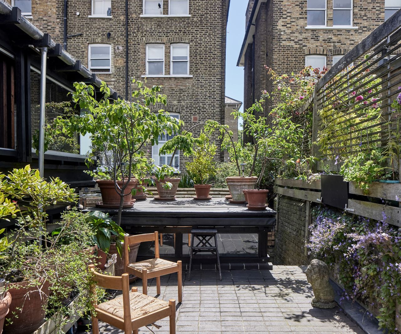 A planting stand with an array of potted plants around it