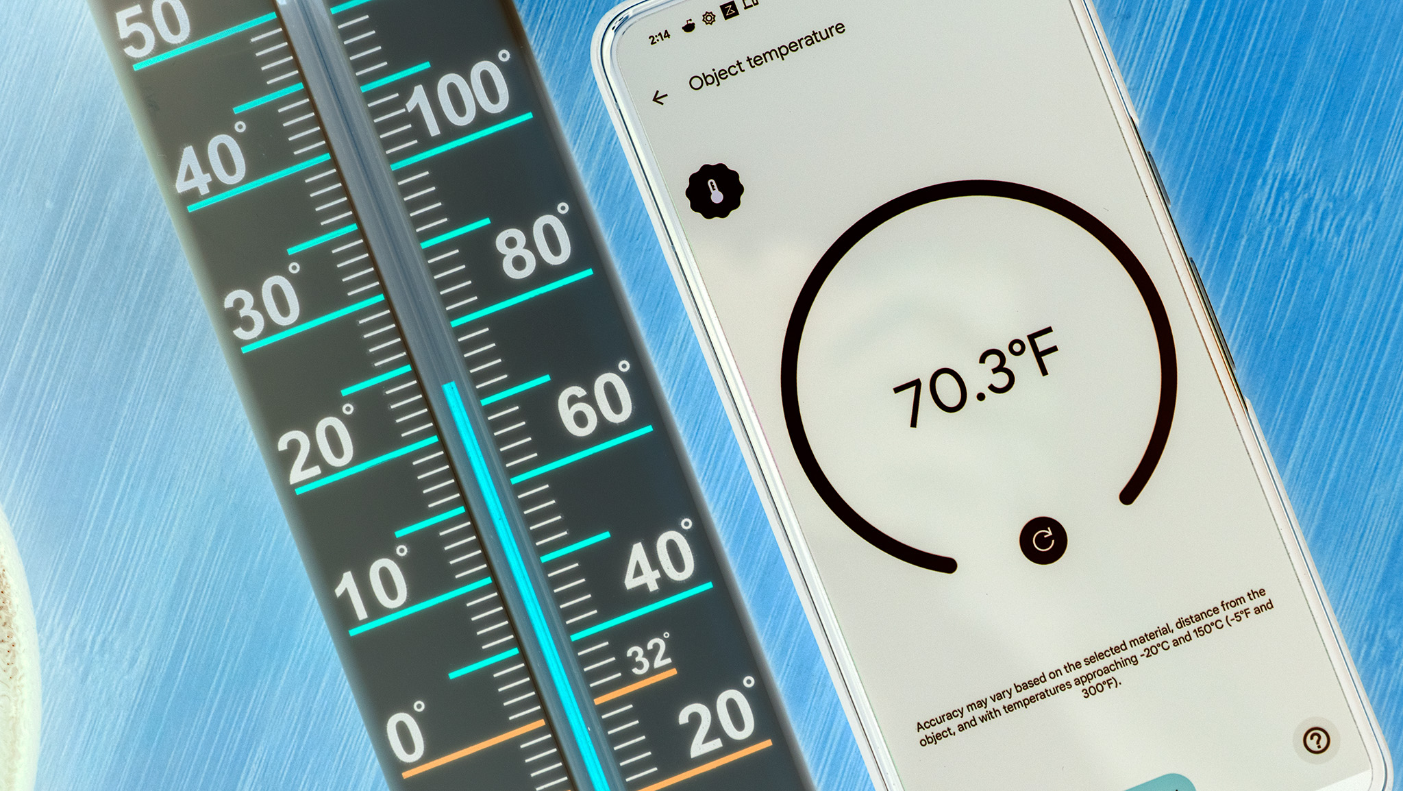 A Google Pixel 8 Pro measuring temperature next to a thermometer