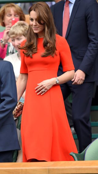 Kate Middleton wears a red dress and carries a leopard print clutch as she attends day nine of the Wimbledon Tennis Championships at Wimbledon on July 8, 2015