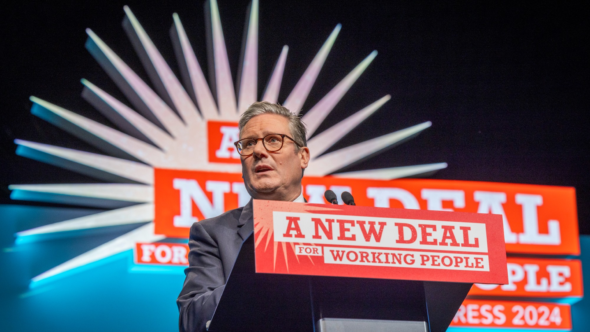 Keir Starmer speaking at the 2024 Trades Union Congress, at a podium reading ‘a new deal for working people’