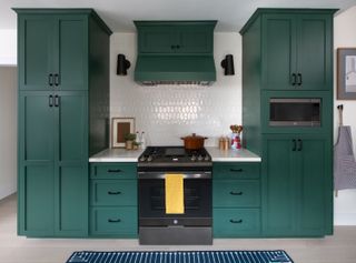 A kitchen with dark green cabinets