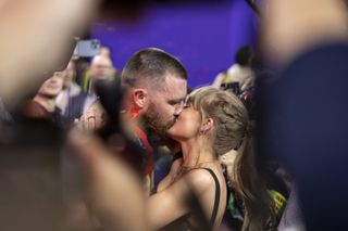 Travis Kelce #87 of the Kansas City Chiefs celebrates and kisses Singer Taylor Swift following the NFL Super Bowl 58.