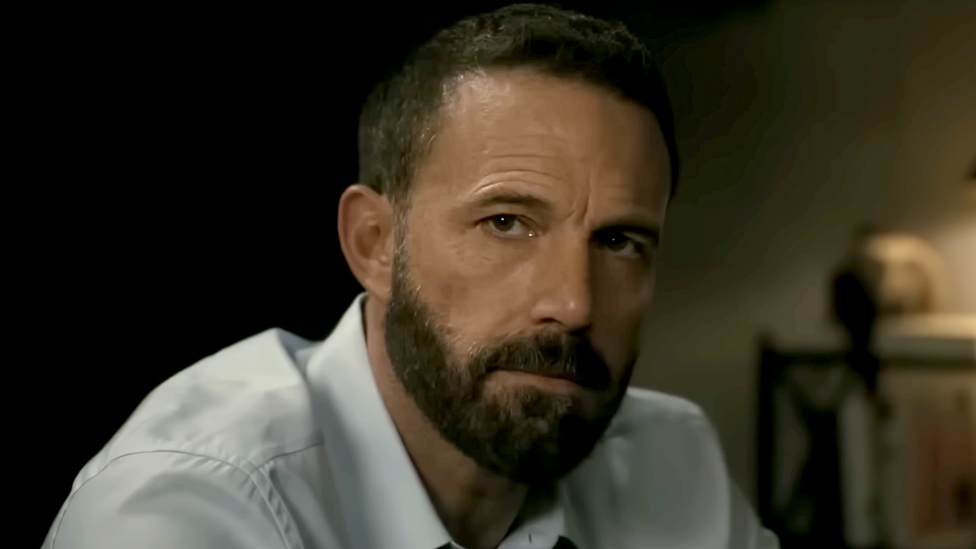 A bearded Ben Affleck, in a white dress shirt and open collar, starring and directing his film 'Animals.' 