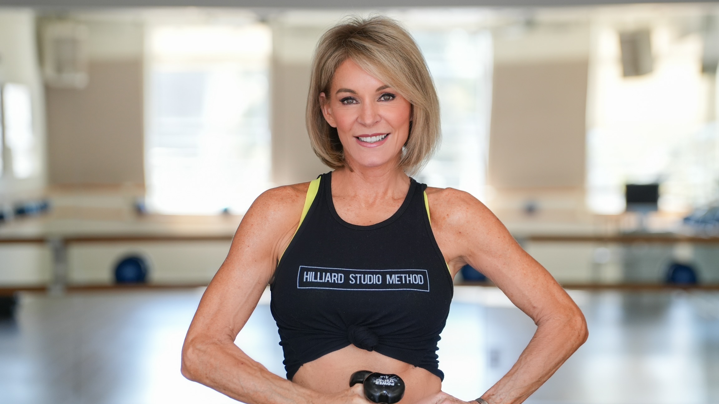 Woman stands in fitness studio looking at the camera