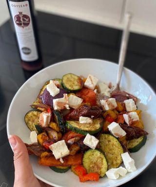 Chunky mediterranean style vegetables in white bowl with feta cheese and pomegranate molasses