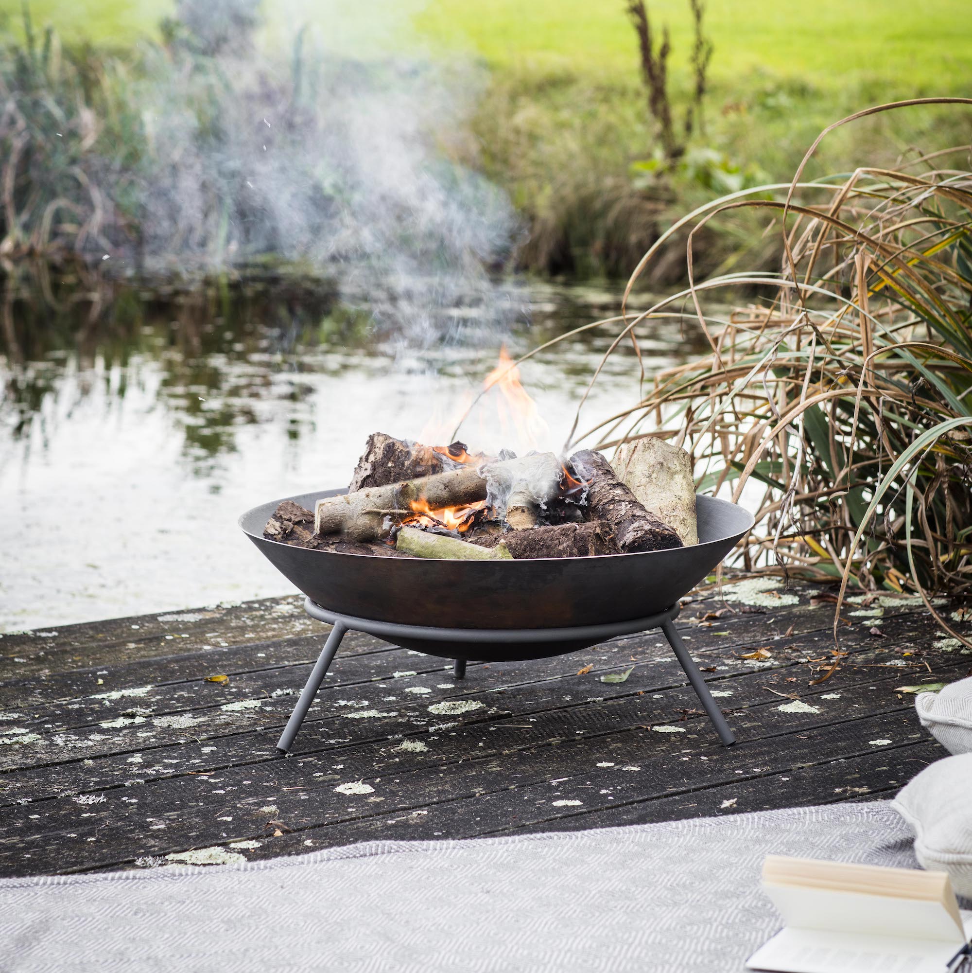 smoking fire pit near pond