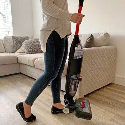 Woman using the Ewbank HYDROH1 2-In-1 Cordless Hard Floor Cleaner