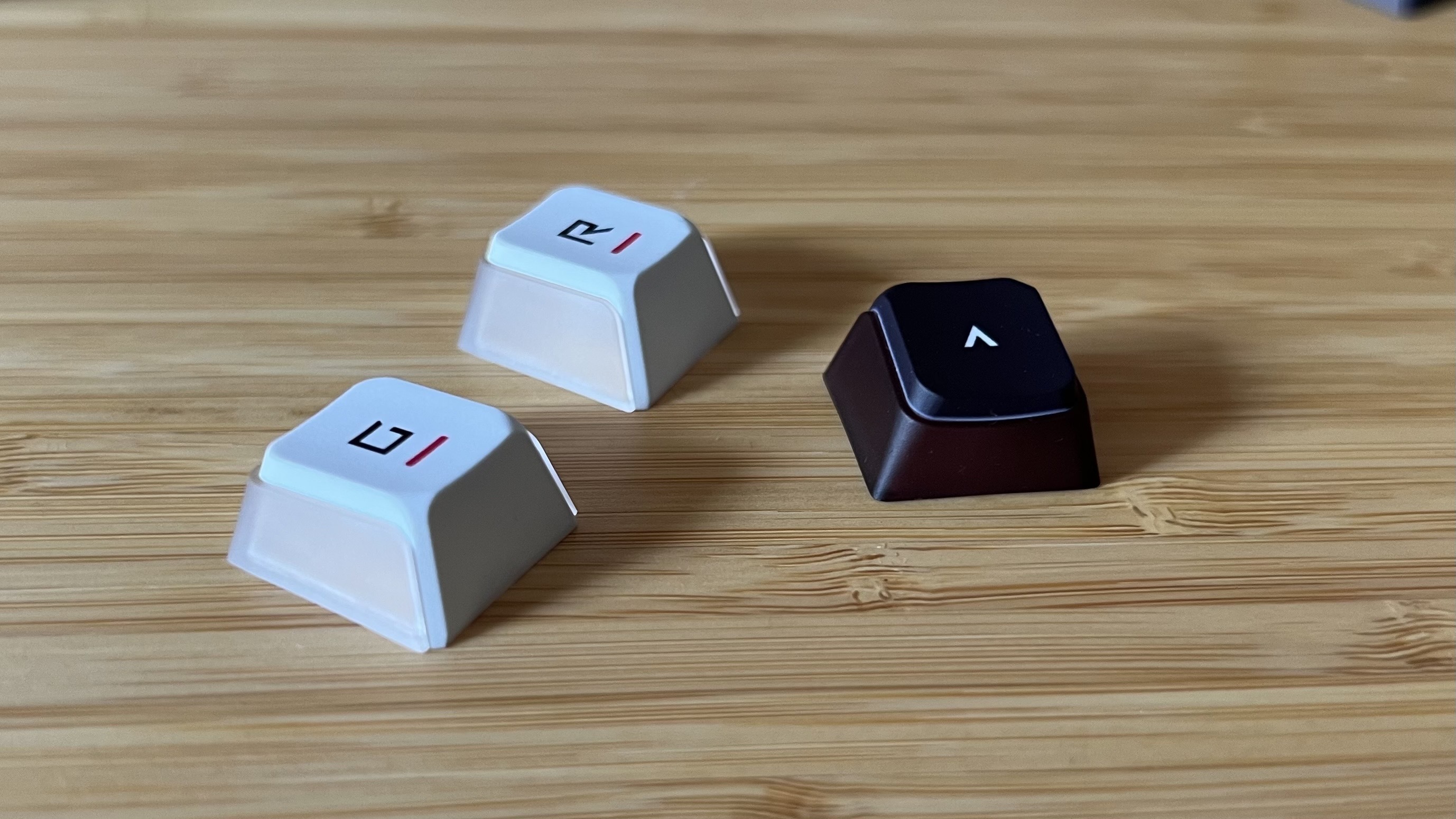 Keycaps from Asus ROG Azoth X gaming keyboard on a wooden desk