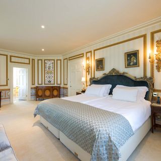 bedroom with white bedlinen and wooden shelf