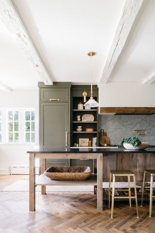 farmhouse style kitchen with olive green cabinets and herringbone floors