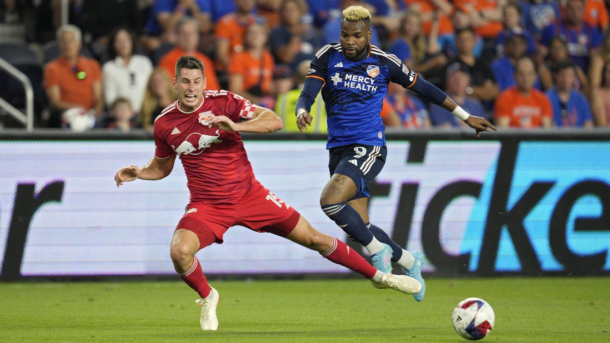 Sean Nealis (L) clears the ball away from Aaron Boupendza (R) ahead of the MLS Cup Playoffs