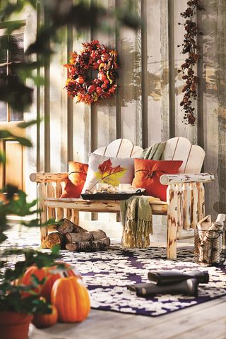 outside fall decor with bench and cushions, fall wreath and hanging garland