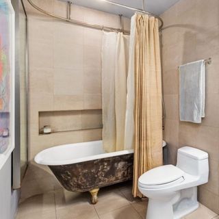 bathroom with tiled floor and walls and bathtub