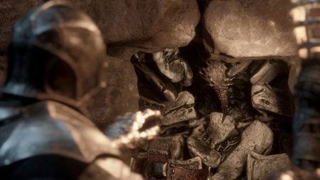 The player reaches out for Vatra's Seal, one of the Mortal Shell 2 Seals, which is embedded in a wall.
