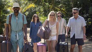 Colman Domingo, Tina Fey, Will Forte, Steve Carell and the new girl all walking in beachwear with luggage. 