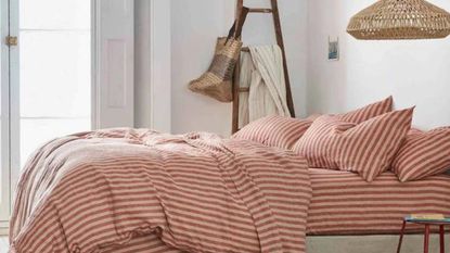 One of the best New Year bedding deals at Piglet in Bed - Sandstone Red Pembroke Stripe Linen Bundle - on a bed.