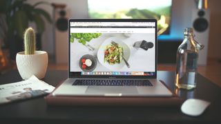 laptop open on a desk with a food website displayed