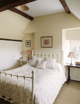white framed bed in bedroom with cream walls
