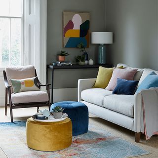 Modern grey living room ideas with pale grey sofa and yellow and blue pouffes