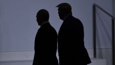 In silhouette, Donald Trump (R) walks with Russia's President Vladimir Putin at the G20 Summit in Osaka in 2019