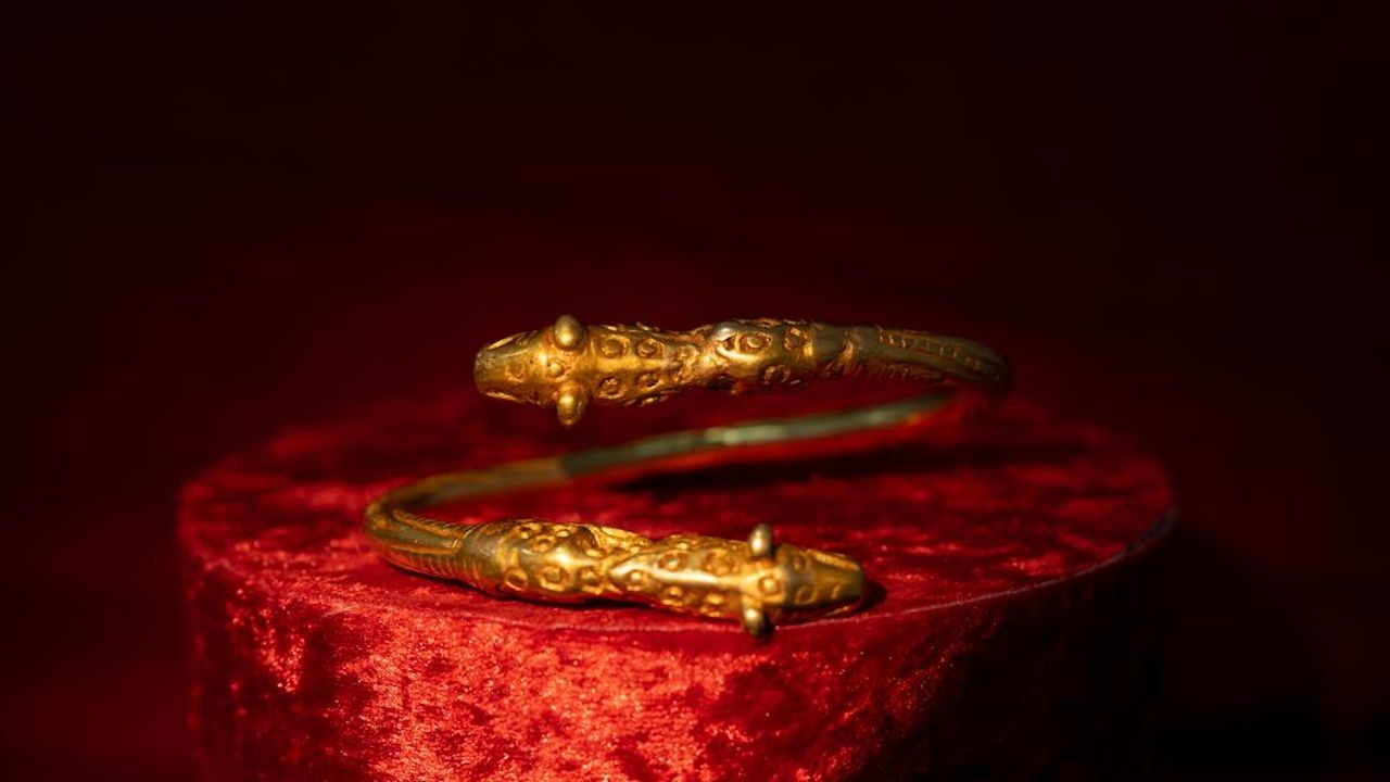 A gold twisted bangle with the head of a leopard, viewed from the side
