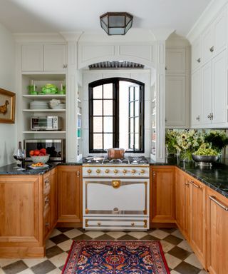 Kitchen with wooden base cabinets, white wall cabinets and range and checkerboard floor
