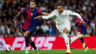 Kylian Mbappe of Real Madrid CF battles for the ball with Inigo Martinez of FC Barcelona during one of the biggest games of the La Liga 2024/25 season