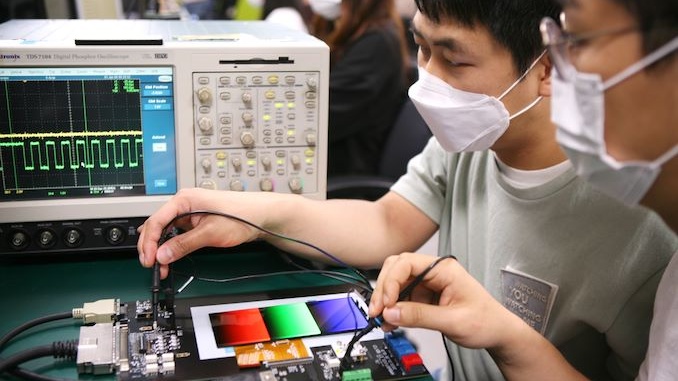 Engineers from Samsung Display using testing devices to inspect frequency changes in display panels that feature adaptive frequency technology. 