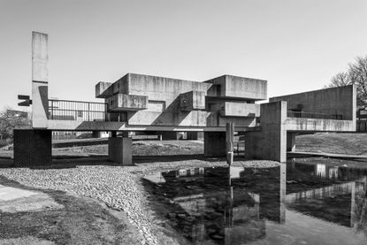 A black & white photo of a sculpture/bridge with intersecting cast concrete planes.
