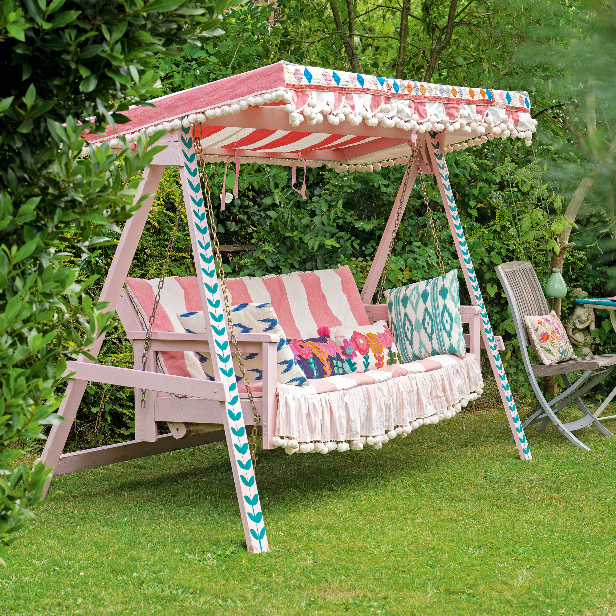a colourful painted swing seat in a garden