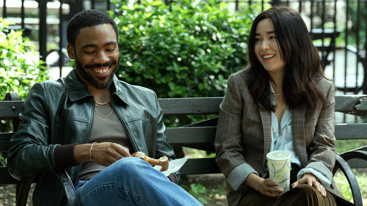 John and Jane share a joke while sitting on a park bench in Mr and Mrs Smith season 1