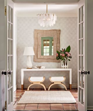 A coastal-style entryway with white glass-paned doors and a small console table