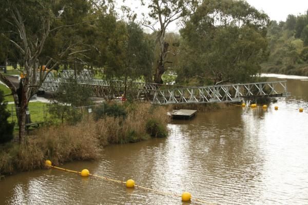The water level sits well below even the temporary bridge at normal levels.