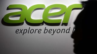 A shadowy man walks by the green Acer logo