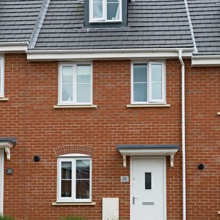 Red brick terraced house with whit windows, doors and guttering