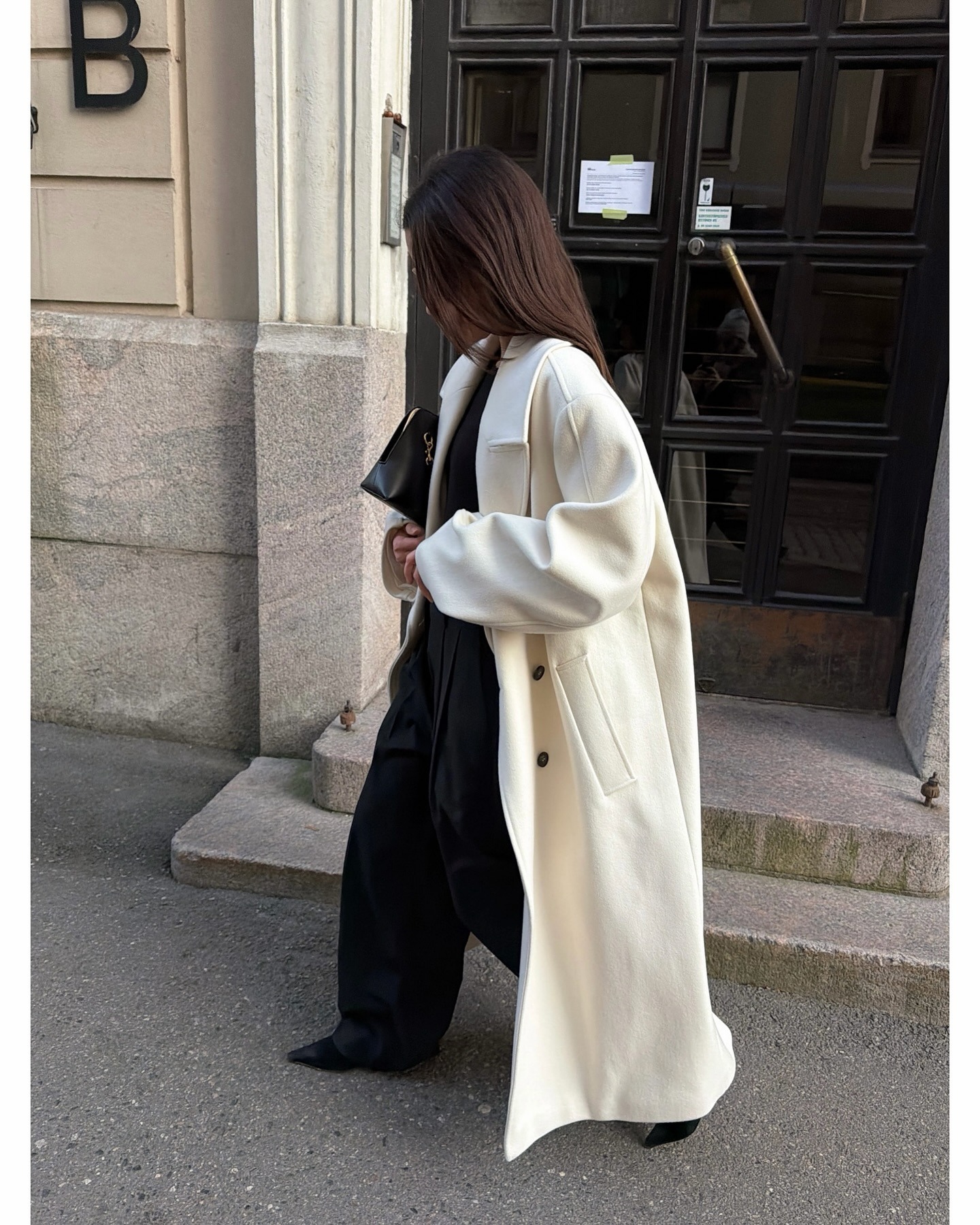 Woman wearing white ivory coat for winter 2026.