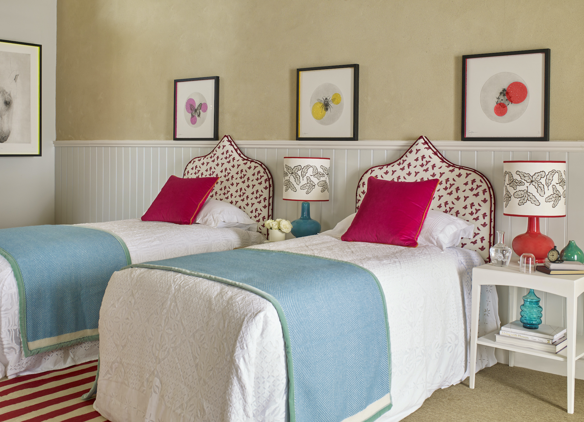 twin beds with upholstered headboards and red cushions