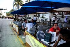 People eat in the outdoor dining area of a restaurant on Ocean Drive in Miami Beach, Florida on June 24, 2020.